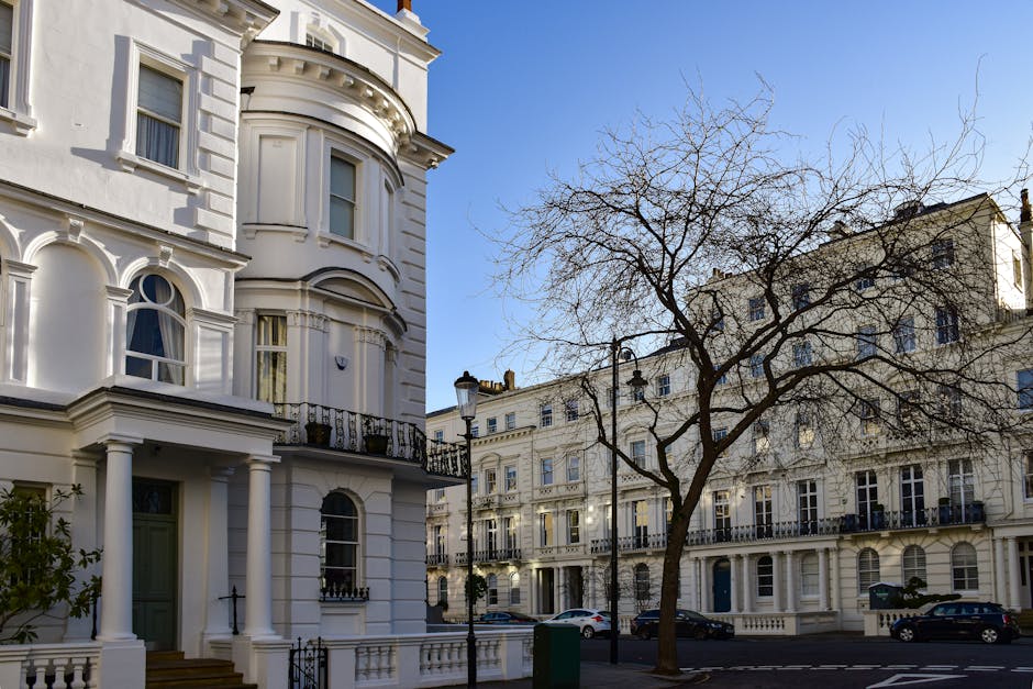 An exterior view of a row of traditional brick residential flats located on Fulham Road, with a narrow sidewalk in front. The buildings feature multiple stories, each with white-framed windows and decorative stone lintels. The brickwork shows signs of weathering, and the pavement along the sidewalk has some fallen leaves and minor debris, indicating the need for surface cleaning and maintenance. The scene is illuminated by natural daylight, highlighting the textures of the brick and stonework. This image relates to domestic cleaning services offered by Cleaners SW10, focusing on maintaining and revitalising exterior surfaces of residential properties in the SW10 area, including thorough surface cleaning and exterior sanitisation, aligning with their end of tenancy cleaning for flats on Fulham Road.